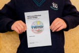 A kid holding their drawing