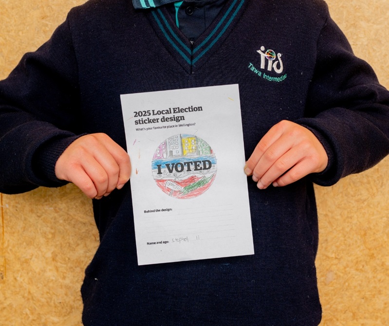 A kid holding their drawing