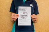 A kid holding their drawing