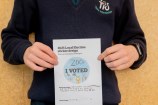 A kid holding their drawing