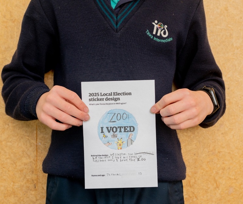 A kid holding their drawing
