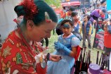 A child getting their face painted at a Christmas event.