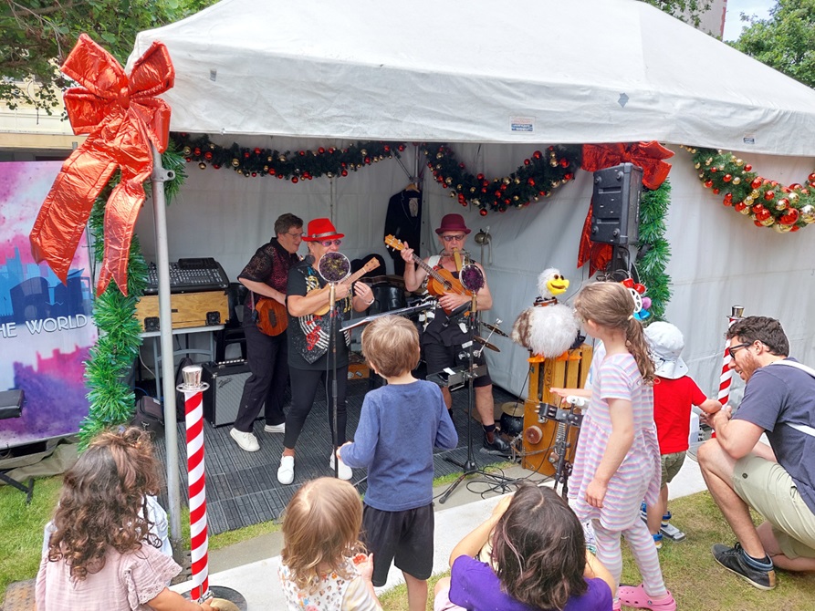 A band playing to an audience of children dancing.