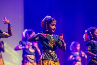 Children dancing on stage at a Diwali concert.