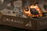 Detail photo of a lit brazier, engraved with the word 'Ururangi'.