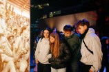 Four young people looking at a lightbox showing historical images of the Māori battalion.