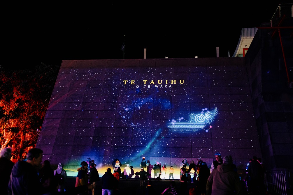 Children and families gather to watch a star map projection on the south side of Te Papa.