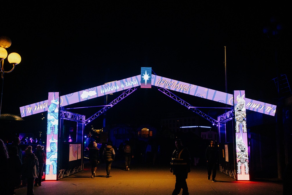 A stylised marae entrance gate constructed from LED panels. It is displaying a changing pattern of animated artworks.