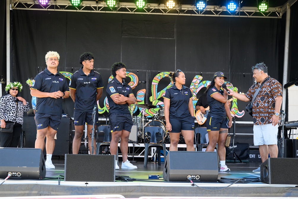 A group of Hurricanes rugby team players are interviewed on stage.