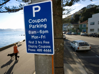 Blue coupon parking street sign showing parking days of the week, times and conditions.