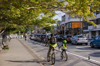 Two cyclists riding down Adelaide Road in Newtown.