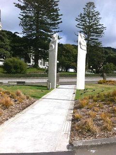 A pathway between two tall Maori statues.