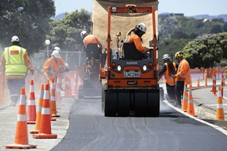 Workers tarsealing a road in Wellington.