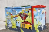 Electricity box painted in bright, colourful, streetscene.