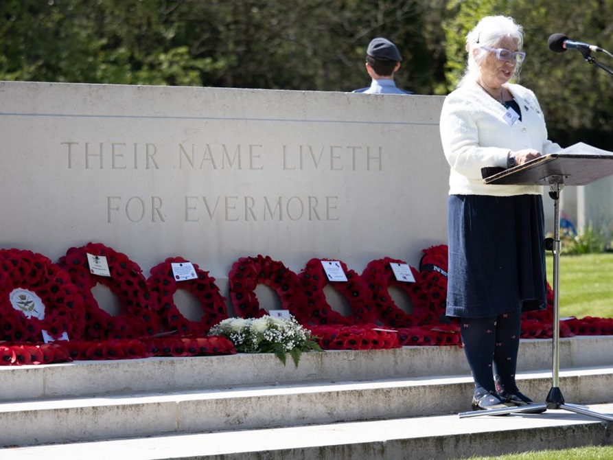 A woman speaks from a lectern in front of the Anzac memorial.