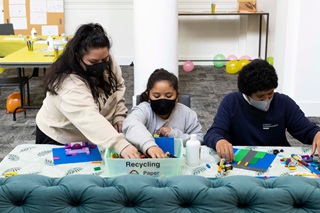 A group of young people playing with Lego blocks.
