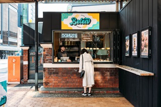 A customer viewing the cabinet food at Belen Vegan Bakery on Courtenay Place 