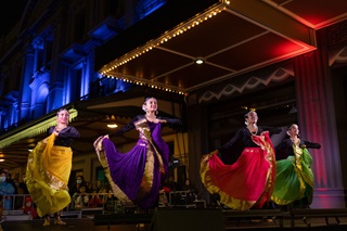 Indian dancers in colourful clothing dancing on stage.