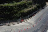 Bottom of the Ngaio Gorge slip showing the fence, road, and road cones.