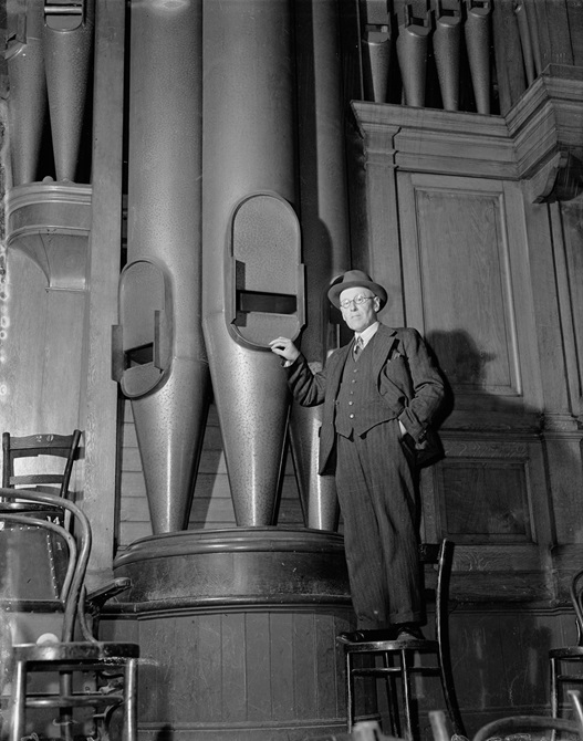 H. A. Tustin standing beside the largest of Wellington Town Hall's organ pipes in 1906.