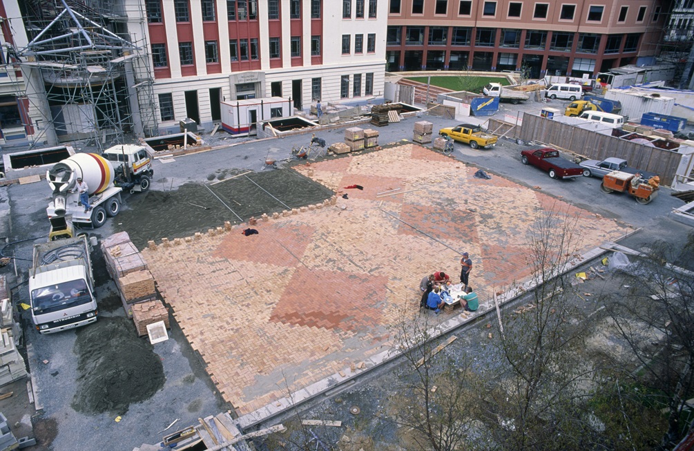 Workers picnic on the initial patch of Civic Square's new surface tiles.