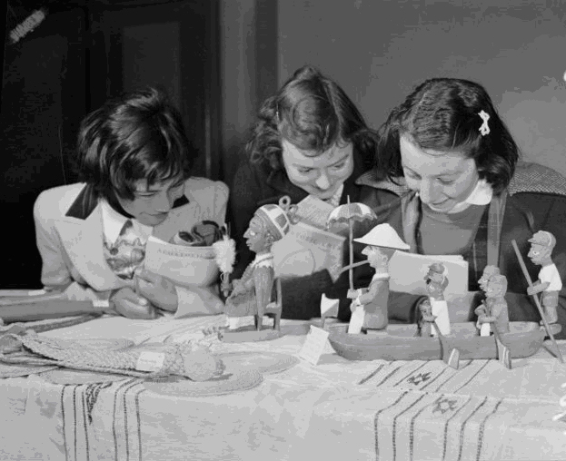 Three girls look at missionary exhibits at the Town Hall in 1951.