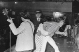 Police restraining a fan who has seized Mick Jagger during a Rolling Stones concert at the Town Hall in 1966.