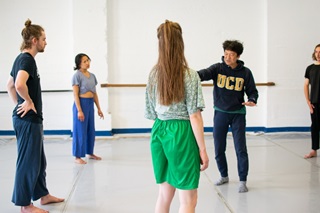 Japanese choreographer Kota Yamazaki and dance students working in a dance studio.