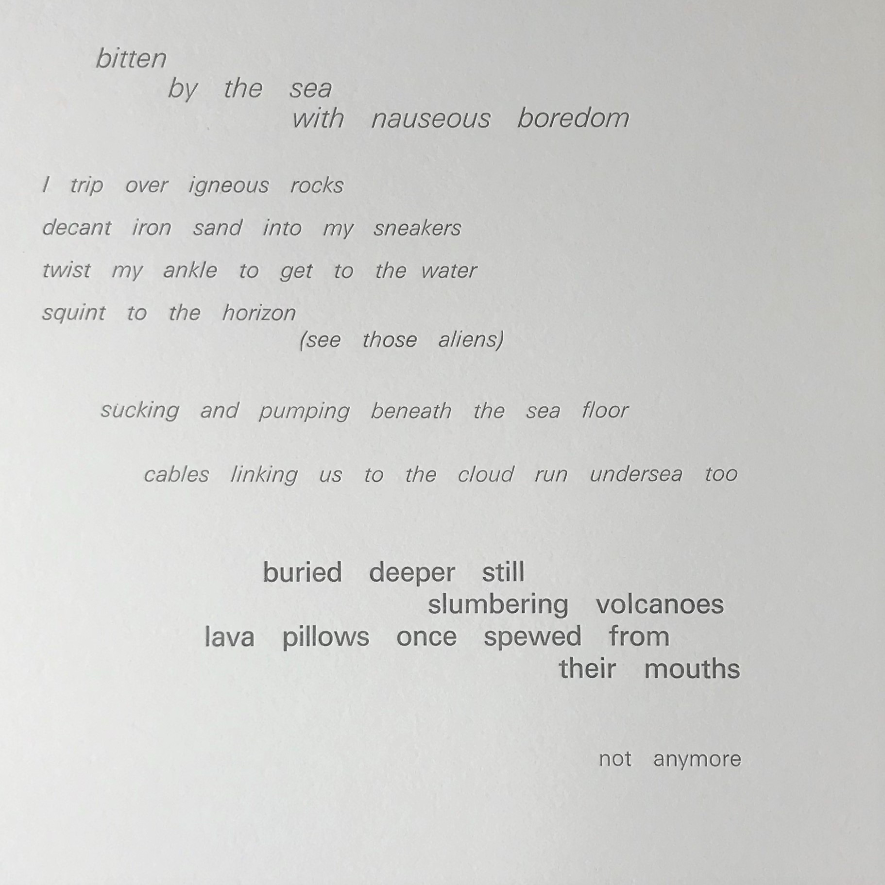 A poem made with old fashioned typeset letters. Ink is a dark grey and is embossed onto a thick ivory paper. Some words have been redacted by using the flat end of the intended letter block. The left margin slopes creating a slight parallelogram shaped block of text. The poem reads: Bitten by the sea with nauseous boredom I trip over igneous rocks decant iron sand into my sneakers twist my ankle to get to the water squint to the horizon (see those aliens) sucking and pumping beneath the sea floor cables linking us to the cloud run undersea too buried deeper still slumbering volcanoes lava pillows once spewed from their mouths not anymore