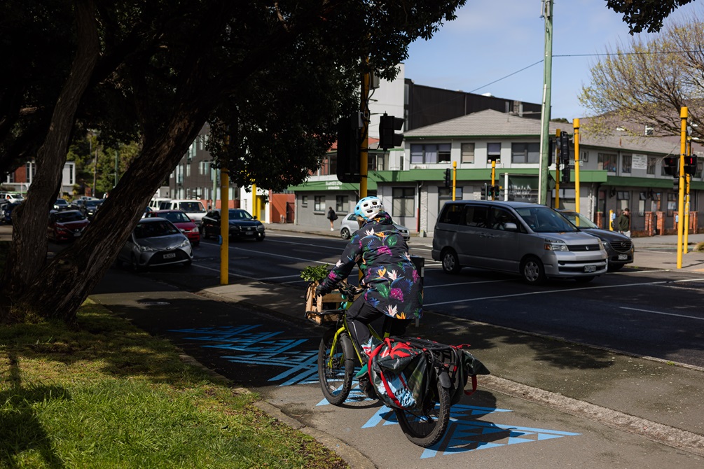 Person riding bike along the bike network, on the footpath are the blue markings to signify the awa that was there.