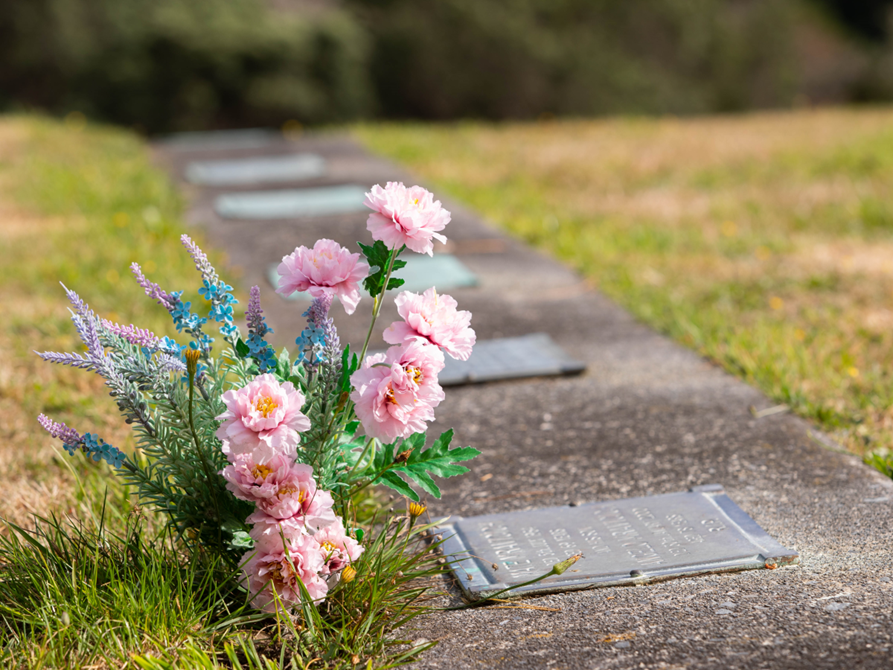 Flowers by a memorial plaque.