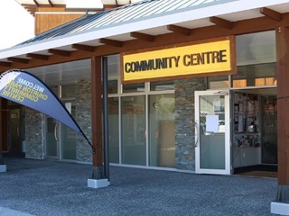 A wide open front door with a sign above saying Community Centre and a flag next to the door.