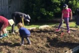 Two adults and two children gardening.