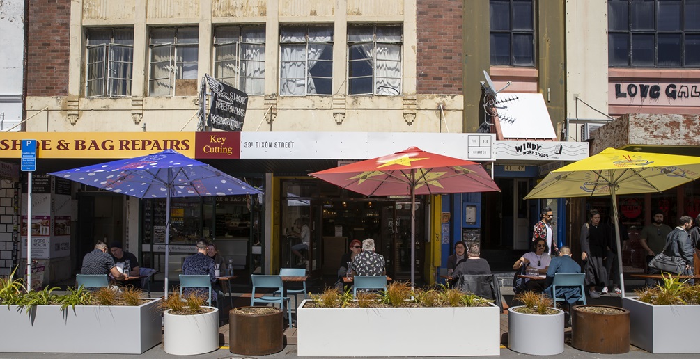 Dixon Street cafes with diners  under colourful umbrellas.