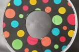 A black collar with colourful dots all over it.