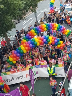 A parade of people carrying colorful balloons.