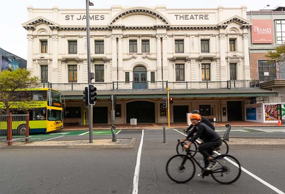 A couple of cyclists on Courtenay Place, across the road from St James Theatre.