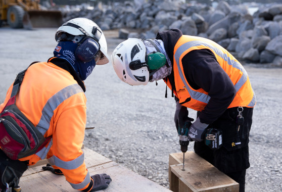 Downer construction workers building penguin nesting boxes with an electric drill