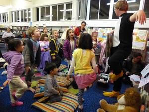 Librarian Stephen Clothier dressed as a penguin while performing story time in front of a bunch of children.
