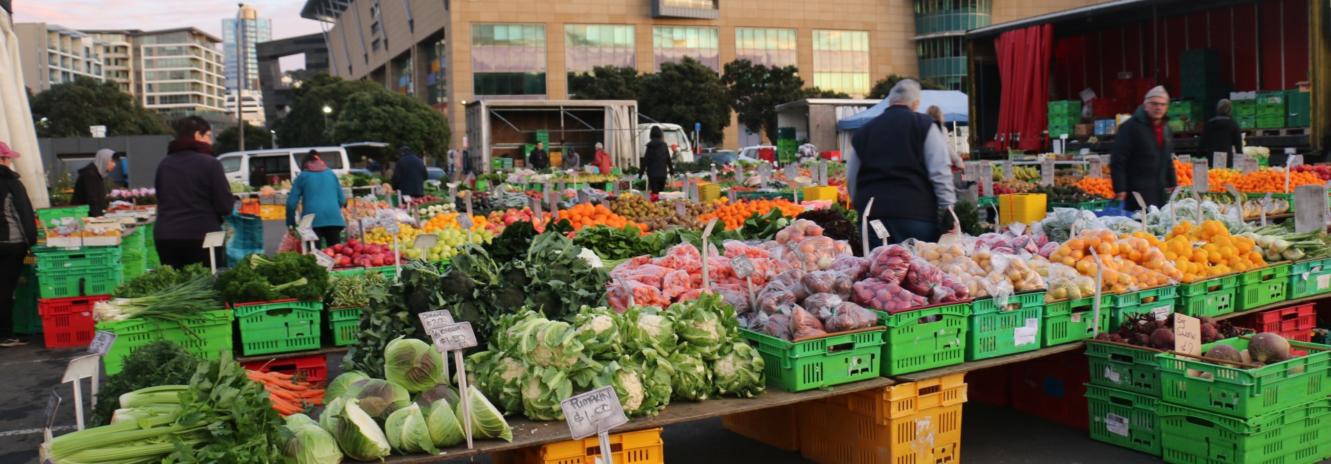 Image of bright fresh fruit and vegetables at the Harbourside Market on Wellington waterfront, with Te Papa in the background.