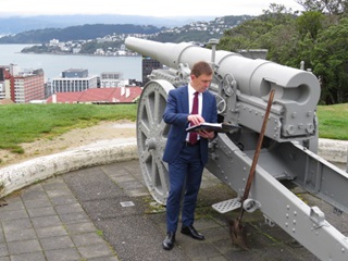 Mayor Andy Foster reading a book near a canon