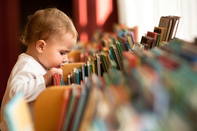 Young child looking at books.