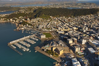 An aerial shot of Wellington harbour, the marina, the Mt Victoria lookout, and the eastern suburbs in the background.