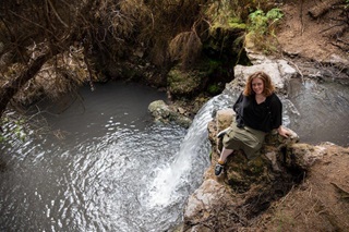 Crystal Filep, from Wellington City Council’s Urban Design team, sitting on rocks at a waterfall.