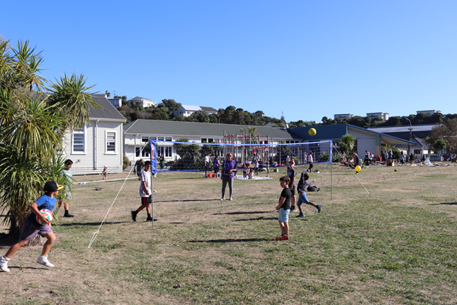 Children playing on the field with a volleyball net and classrooms in the background at Kahurangi School in Strathmore.