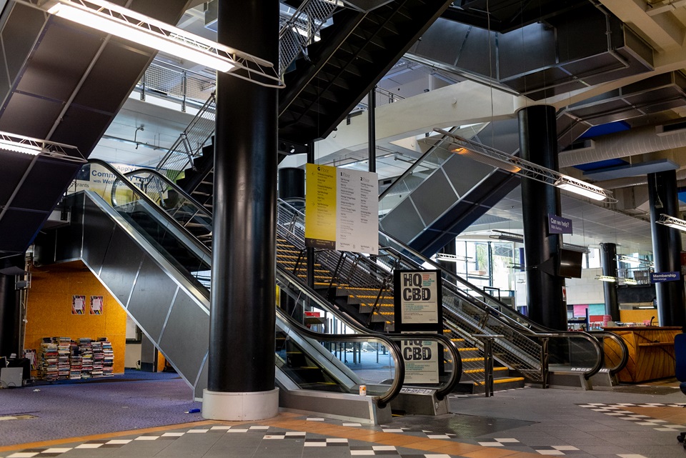 Two escalators and one central set of stairs inside the darkened, closed Central Library.