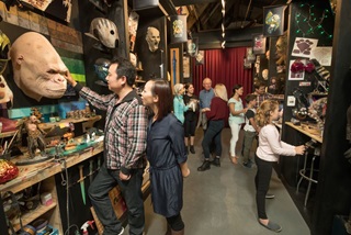 A small group of people explore film props and prosthetics at the Weta Workshop.
