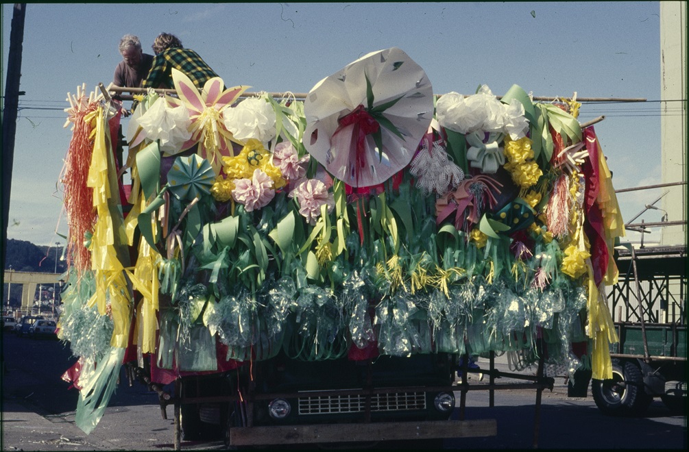 A large colourful float made up of lots of flowing fabric and fake flowers.