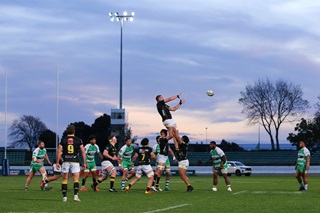 The Wellington Lions rugby team playing on a field at dusk.