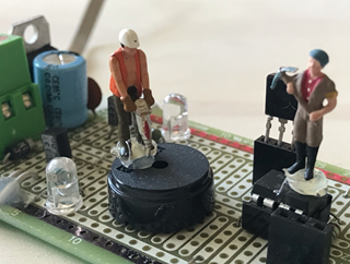 Little miniature contstruction workers on a metal circuit board, pretenting to repair it.